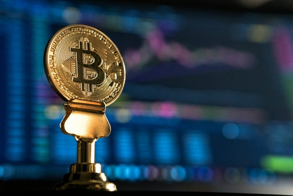 Hut8 stock, selective focus photo of Bitcoin near monitor
